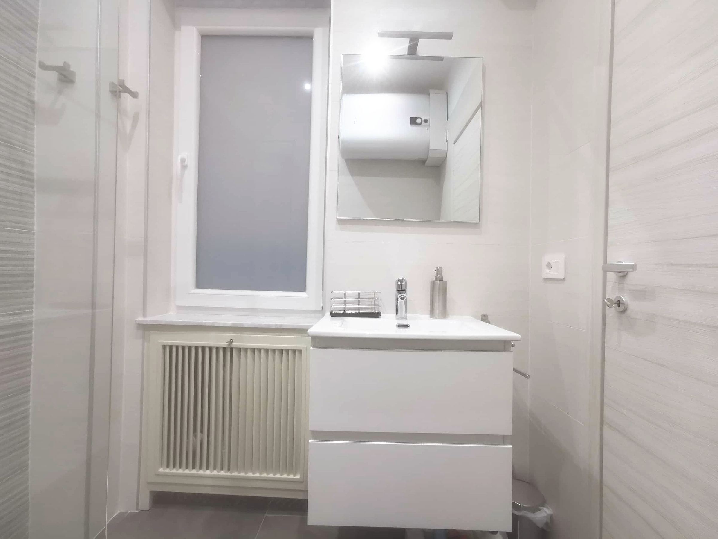Lavabo bianco sospeso a due cassetti, specchio con applique LED e finestra satinata